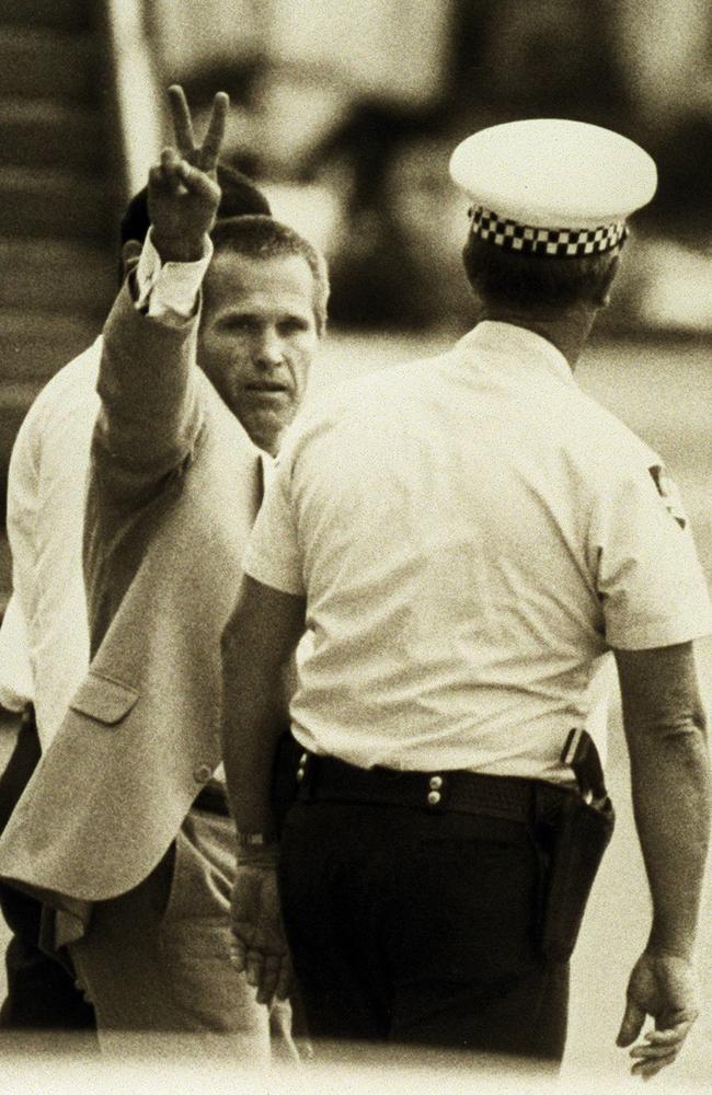 Whiskey Au Go Go killer James Finch is escorted through Brisbane Airport by police on his release in 1988. Picture: Supplied