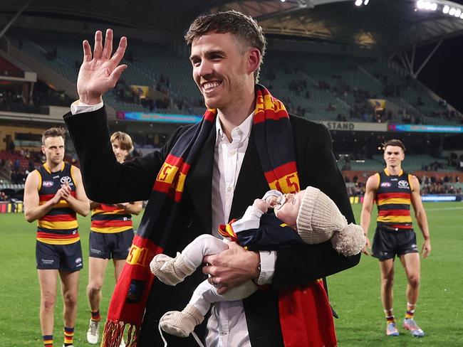 ADELAIDE, AUSTRALIA - AUGUST 19: Paul Seedsman of the Crows walks off the oval with his baby - retiring during to concussion during the 2023 AFL Round 23 match between the Adelaide Crows and the Sydney Swans at Adelaide Oval on August 19, 2023 in Adelaide, Australia. (Photo by Sarah Reed/AFL Photos via Getty Images)