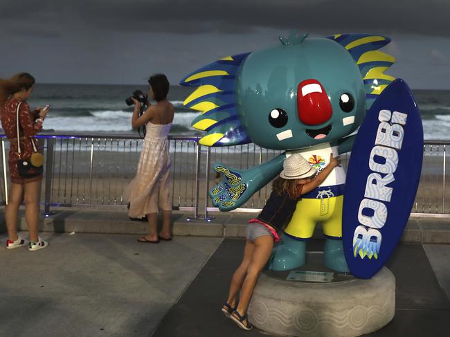 A girl hugs Commonwealth Games mascot, Borobi, at the Surfers Paradise. Picture: AP