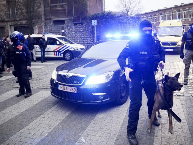 Closing in ... Policemen block a road, near the scene of a police raid in the Molenbeek-Saint-Jean district in Brussels.  Picture:  AFP