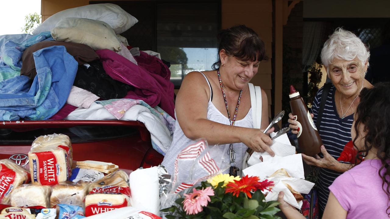 Evelyne Young, Janine Rubio and Sarah Young, 9, helping to feed their Deception Bay street in 2011.