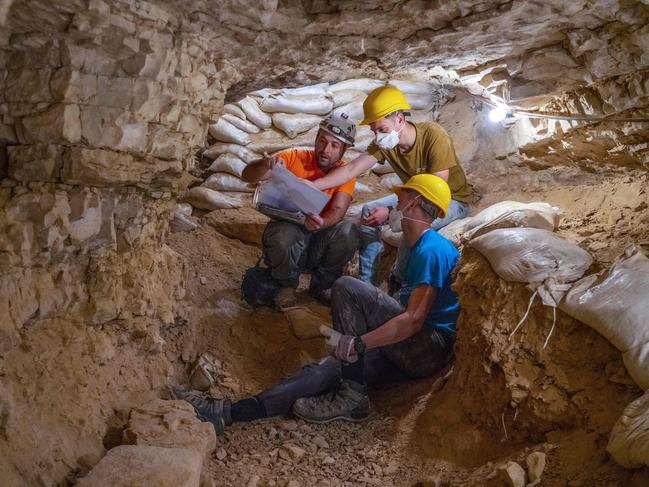 A handout picture provided by the Israeli Antiquities Authority on March 16, 2021, shows a photo taken on February 4, 2020, of volunteers and archaeologists taking part in cave excavations in the Judean Desert. - Israel considered the find, which includes a cache of rare coins, a six-millennia-old skeleton of a child, and basket it described as the oldest in the world at over 10,000 years, as one of the most significant since the Dead Sea Scrolls. The fragments, found following a survey in a desert area spanning southern Israel and the occupied West Bank, include passages in Greek from the Book of the Twelve Minor Prophets including the books of Zechariah and Nahum, the IAA said. (Photo by Yaniv Berman / Israeli Antiquities Authority / AFP) / RESTRICTED TO EDITORIAL USE - MANDATORY CREDIT "AFP PHOTO / HO / ISRAEL ANTIQUITIES AUTHORITY" - NO MARKETING NO ADVERTISING CAMPAIGNS - DISTRIBUTED AS A SERVICE TO CLIENTS / XGTY