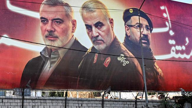 A man walks beneath a giant billboard showing pictures of the slain figures (L to R) Palestinian Hamas' political leader Ismail Haniyeh, Iran's Islamic Revolutionary Guard Corps' (IRGC) Quds Force commander Qasem Soleimani, and Lebanese Hezbollah's commander Fuak Shukr, in Lebanon. Picture: AFP.