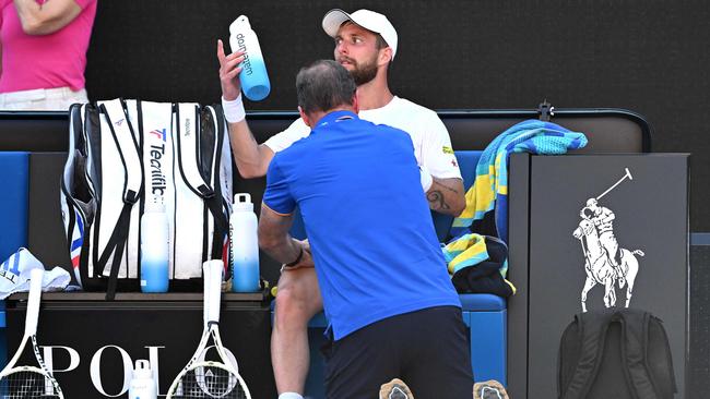 France's Corentin Moutet receives medical attention. Photo by Paul Crock / AFP.