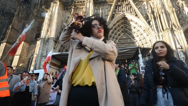 A protester is seen cutting her hair during the new protest against Islamic regime in Iran. Picture: Ying Tang/NurPhoto via Getty Images