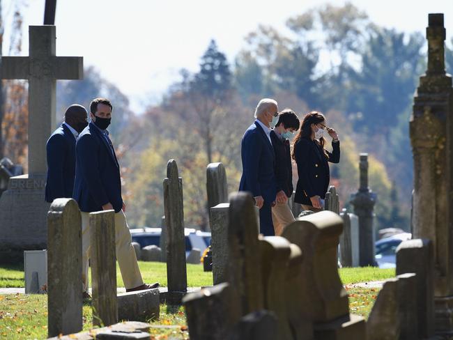 He was flanked by security as he visited the cemetery. Picture: AFP