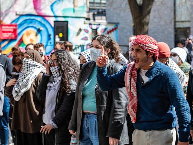 Pro-Palestinian protesters stand in front of a police barricade after police raided an encampment at Northeastern University in Boston, Massachusetts, on April 27, 2024. Police detained about 100 people as they moved in to clear an encampment of pro-Palestinian protesters in response to the use of anti-Semitic slurs, Northeastern said. (Photo by Joseph Prezioso / AFP)