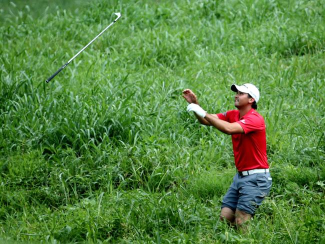 Jason Day catches his golf club after finding the ball.