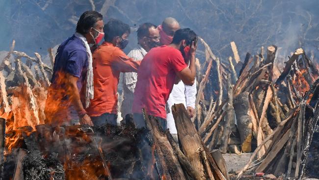 Relatives perform the last rites amid the funeral pyres of Covid victims at a crematorium in New Delhi. Picture: AFP