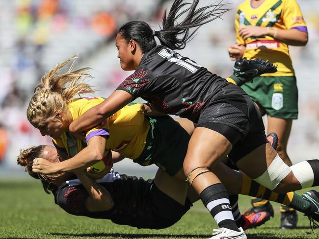 Renae Kunst of the Jillaroos is tackled by Amber Kani (L) and Lilieta Maumau of the Ferns.