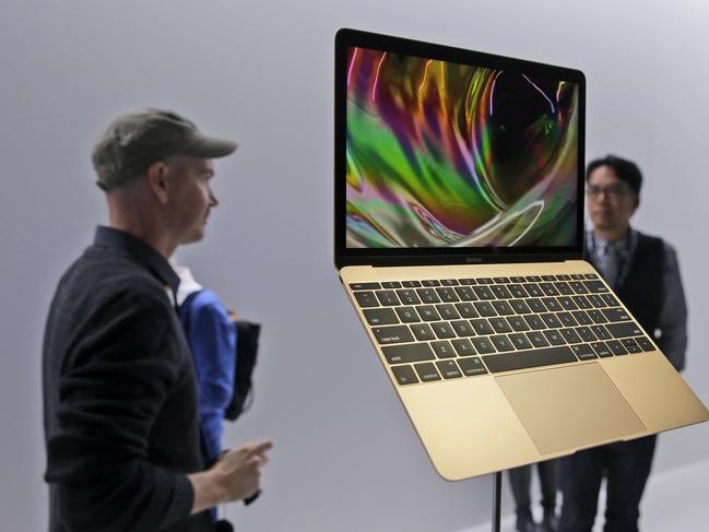 FILE - In this March 9, 2015 file photo, members of the media and Apple guests get a look at the new MacBook in the demo room after an Apple event in San Francisco. The company will debut the new laptop on Friday, April 10, 2015. (AP Photo/Eric Risberg, File)