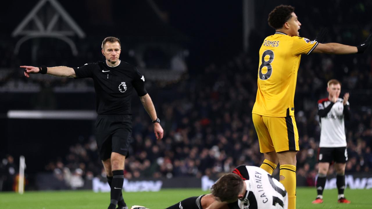 Referee Michael Salisbury points to the penalty spot, as Tom Cairney of Fulham holds his leg whilst lead on the floor, during the Premier League match between Fulham FC and Wolverhampton Wanderers at Craven Cottage on November 27, 2023 in London, England. (Photo by Alex Pantling/Getty Images)