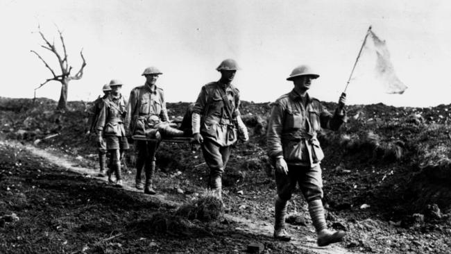 Stretcher bearers carrying white flag while returning from battle with wounded soldier in Pozieres, France during World War I 1916. Picture: Australian War Memorial