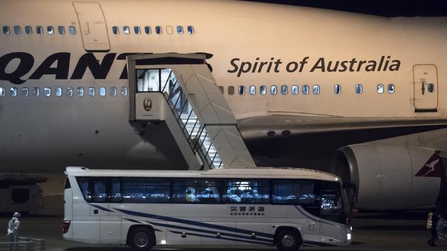 A bus carrying passengers about to board a Qantas aircraft chartered by the Australian government, from the quarantined Diamond Princess cruise ship drive at Haneda airport. Picture: Getty Images