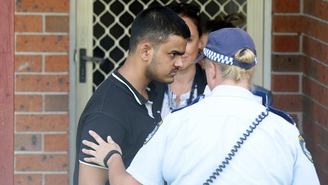 Police comfort a man, believed to be the deceased’s son, at the scene of the death. Picture: Jonathan Ng