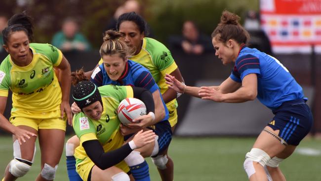 Australia (yellow) vies with France (blue) on the first day of the HSBC World Rugby Women's Sevens Series in Langford, BC, Canada on April 16, 2016. / AFP PHOTO / Don MacKinnon