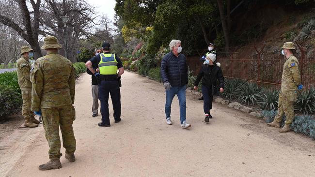 Victoria Police and Australian Defence Force personnel patrol the Tan in Melbourne yesterday. Picture: AFP