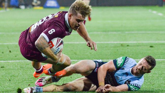 Queensland five-eighth Cameron Munster shrugs off NSW hooker Damien Cook to score Picture: Brenton Edwards