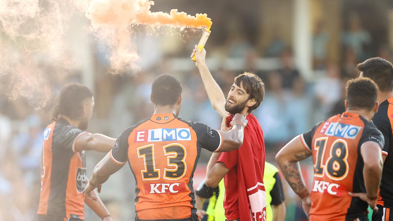 Joe Ofahengaue grabs a pitch invader who ran on the field with a flare (Photo by Mark Kolbe/Getty Images)