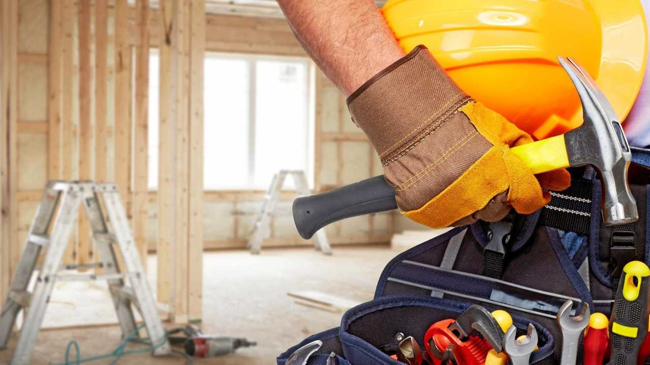 Builder handyman with construction tools. House renovation background.