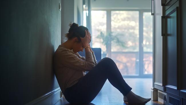 istock generic:  woman, abuse, DV, domestic violence, harassment, sexual harassment.   Sad Young Woman Sitting on the Floor In the Hallway of Her Appartment, Covering Face with Hands. Atmosphere of Depression, Trouble in Relationship, Death in the Family. Dramatic Bad News Moment . Picture: istock