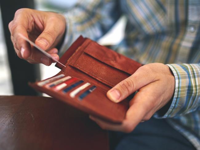 Man buys with a credit card. Generic photo of a wallet, credit cards, paying with credit card. Picture: Mixetto/ Istock