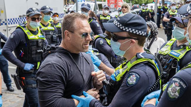 A man is spoken to by police at the protest. Picture: Jason Edwards