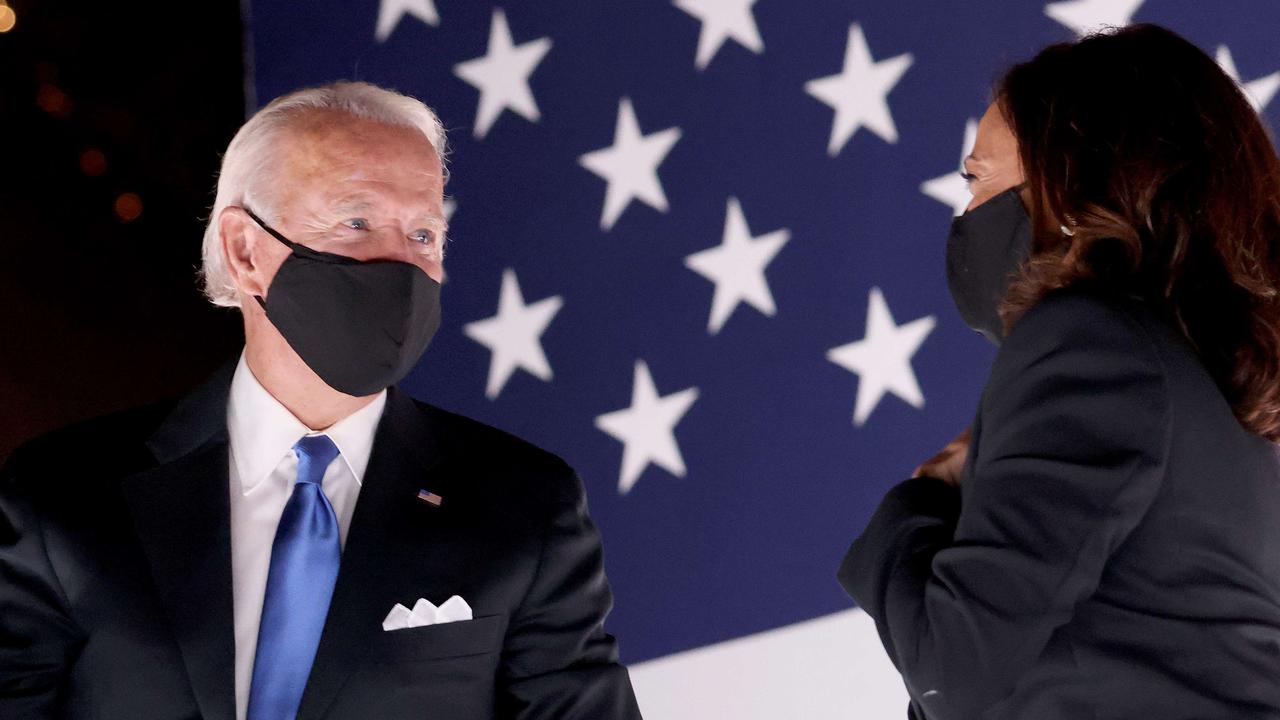 President-elect Joe Biden and Vice President-elect Kamala Harris confer on stage wearing masks. Picture: Win McNamee/Getty Images/AFP