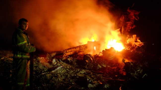 A firefighter stands amongst the wreckage of the Malaysian airliner carrying 298 people from Amsterdam to Kuala Lumpur. Picture: Getty