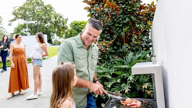 Dennis entertains family and friends around the barbecue. Picture by Luke Marsden.