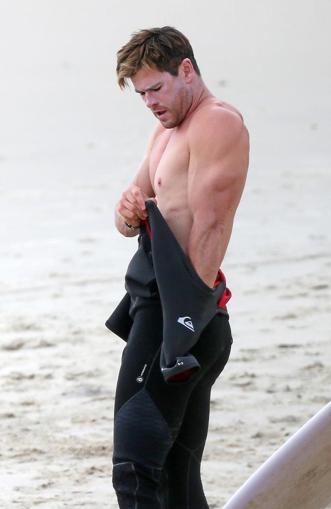 Hemsworth even looks good with zinc all over his face trying to get into a wetsuit. That is no mean feat. Pictures: Backgrid