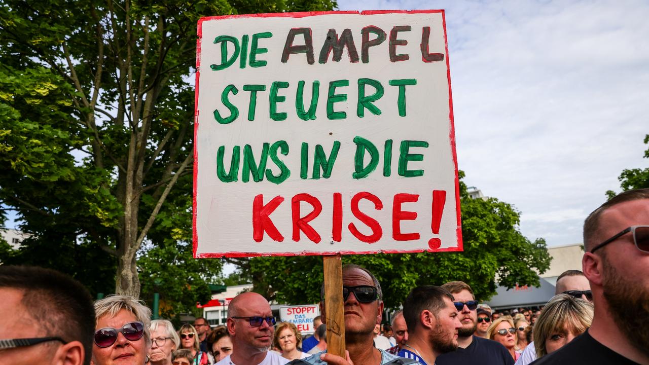 A protester holds a banner reading "The traffic-light (coalition) taxes us during a crisis" as people gather to demand an end to the planned German embargo against the import of Russian oil. Picture: Omer Messinger/Getty Images.