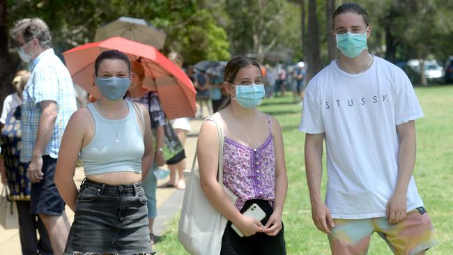 Cousins Angie Carter (left) and Eliza Cutrie, with their friend Liam Mitchell, who works at Avalon RSL, line up at the Avalon Recreation Centre for COVID-19 testing. Picture: NCA NewsWire / Jeremy Piper