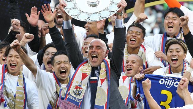 Yokohama F Marinos manager Kevin Muscat (C) holds up the trophy as he celebrates with teammates after taking Japan's professional J-League football title following their 3-1 victory over Vissel Kobe to put them at the top of the standings, in Kobe on November 5, 2022. (Photo by JIJI Press / AFP) / Japan OUT