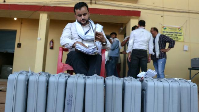 A volunteer sits next to voting machines lined up for sealing after counting at a counting centre in Varanasi on Tuesday. Picture: AFP