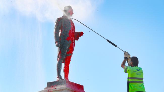 A worker hoses the monument off. Picture: David Crosling