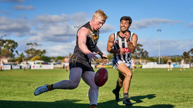 Brighton’s Beau McRae gets a kick away under pressure from PNU’s Anthony Giannini. Picture: Matt Loxton