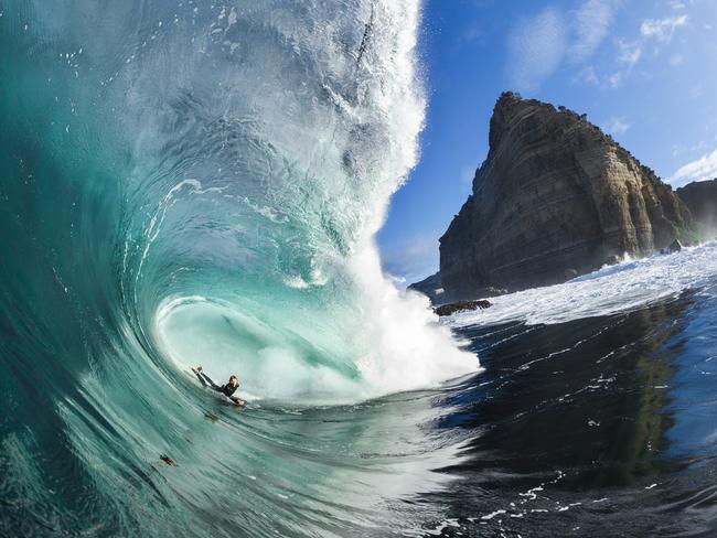 Surfer Harley Ward taking the perfect line through a beautiful Shipstern Bluff wave, with the unique Bluff in full view. For TasWeekend story about a new book by surfer Marti Paradisis called When the Ocean Awakens. Picture: Mat Tildesley