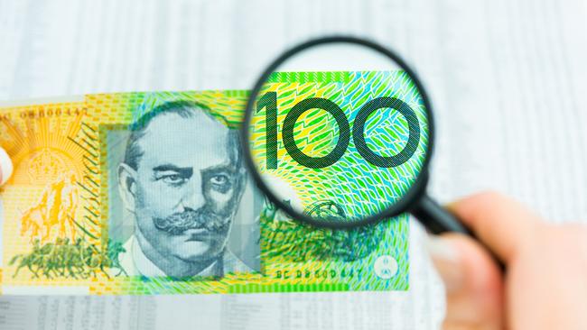 Stock Photo of Australian Money, magnifying glass with $100 note and share market data, tables, investing