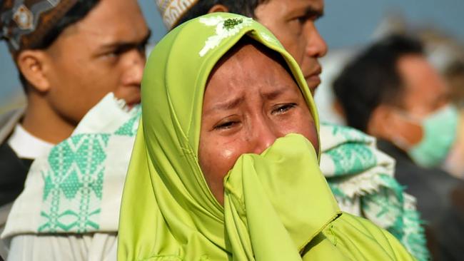 A woman cries as people look at the damages after an earthquake and a tsunami hit Palu. Picture: AFP