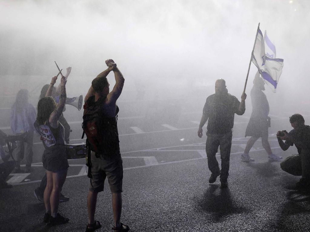 Israeli police spray protesters with water as they block a road during a gathering by relatives of Israeli hostages held in Gaza. Picture: AFP