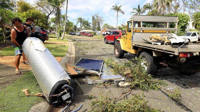 Residents clearing up on a street in Helensvale in the days following the devastating storm. Picture: Adam Head.