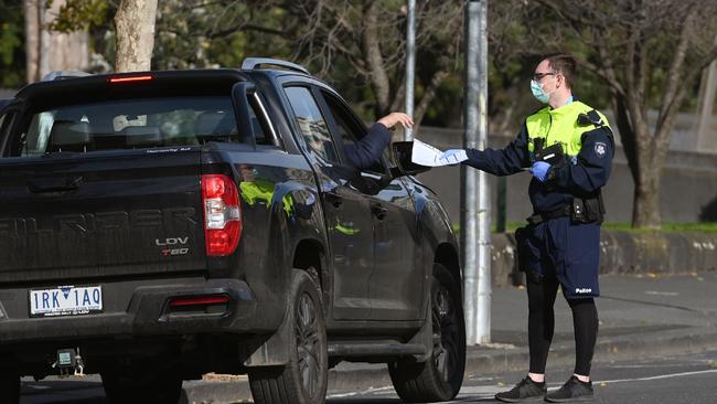 Police officers pull a car over for a licence and permit check in Melbourne. Picture: AFP