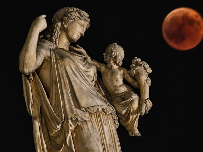 View of the full moon during the "blood moon" next to the ancient Greek goddess Irine in  central Athens. Picture: AFP