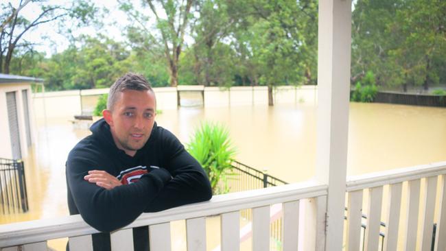 Trent lye on his balcony overlooking his flooded property. Picture: Jake McCallum