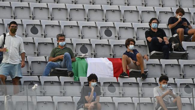 Spectators wear face masks and observe social distancing as they watch a football match in Rome. Picture: Getty Images.