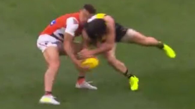 Trent Cotchin puts a big hit on Dylan Shiel.