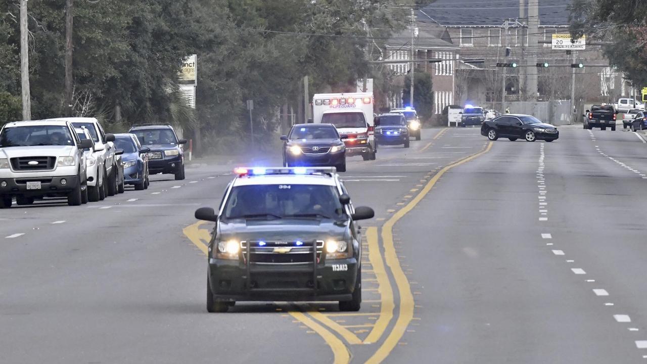 Police cars escort an ambulance after a shooter open fire inside the Pensacola Air Base. Picture: AP