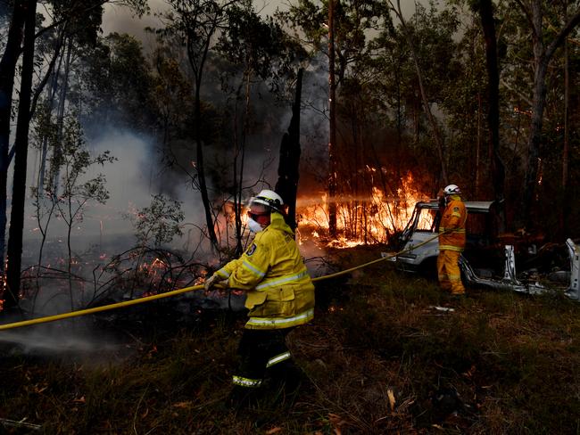 Rural Fire Service (RFS) firefighters conduct property protection near the town of Sussex Inlet on December 31, 2019 in Sydney, Australia. There are a number of dangerous bushfires burning at emergency level across NSW as weather conditions deteriorate with temperatures expected to rise ahead of gusty southerly change. Princes Highway on the NSW South Coast has been closed with motorists told to avoid all non essential travel. Volunteer firefighter Sam McPaul was killed when his truck rolled over in a freak wind event near Jingellic near the NSW-Victorian border on Monday evening. Picture: Sam Mooy/Getty
