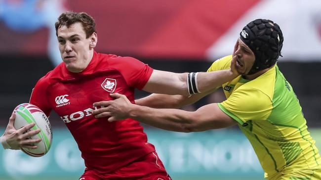 Michael Wells tries to bring down Canada's Phil Berna in the Challenge Trophy final at the World Rugby Sevens Series in Vancouver. Picture: AP